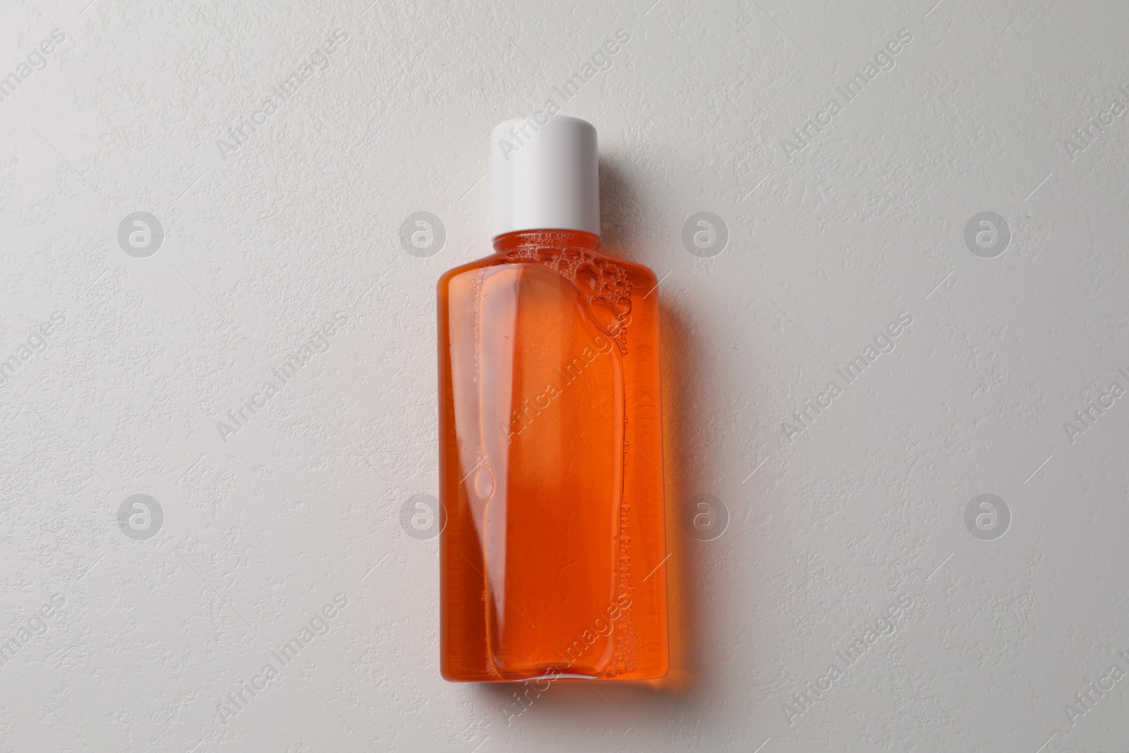 Photo of Fresh mouthwash in bottle on white background, top view