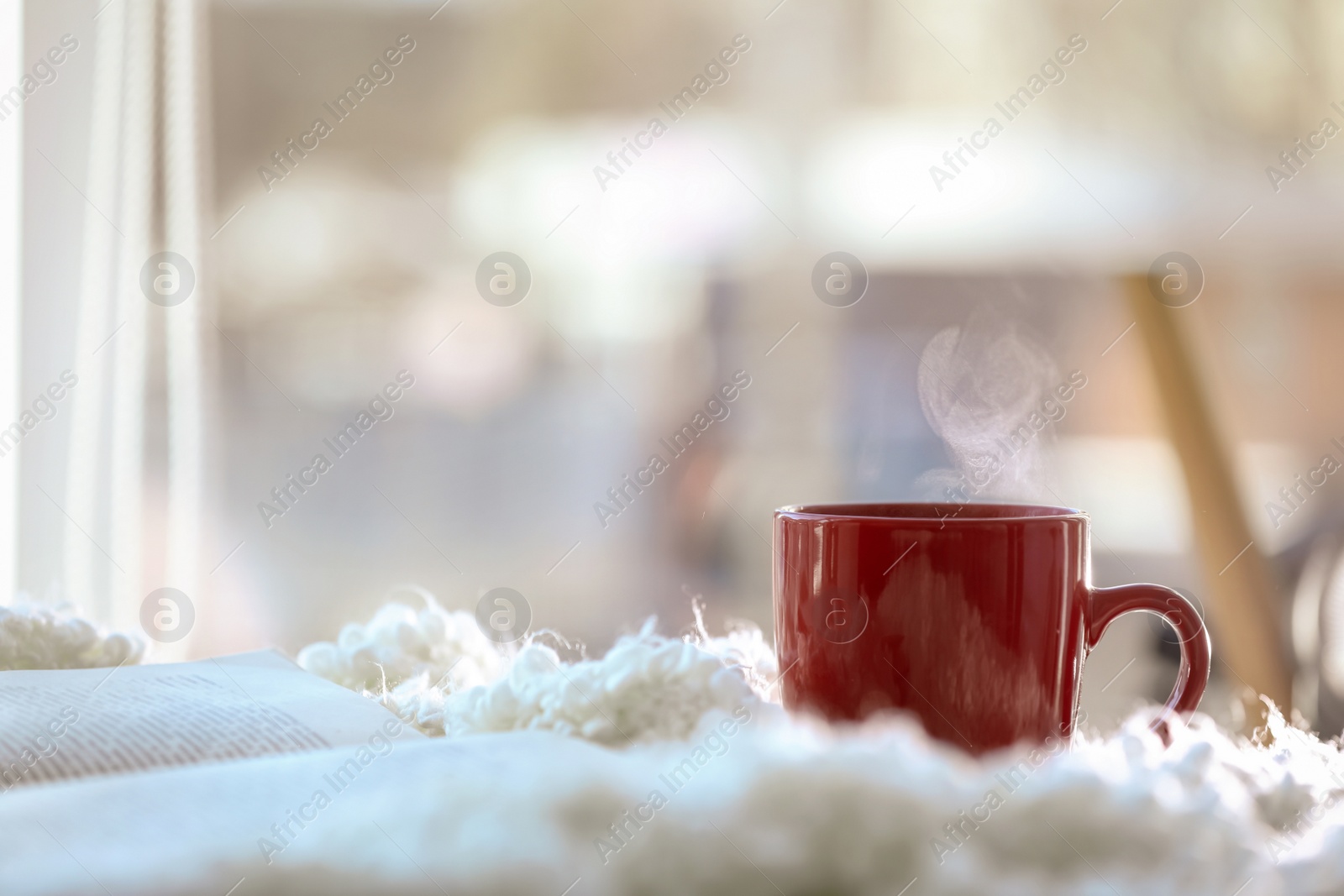 Photo of Cup of coffee and book near window in morning. Space for text