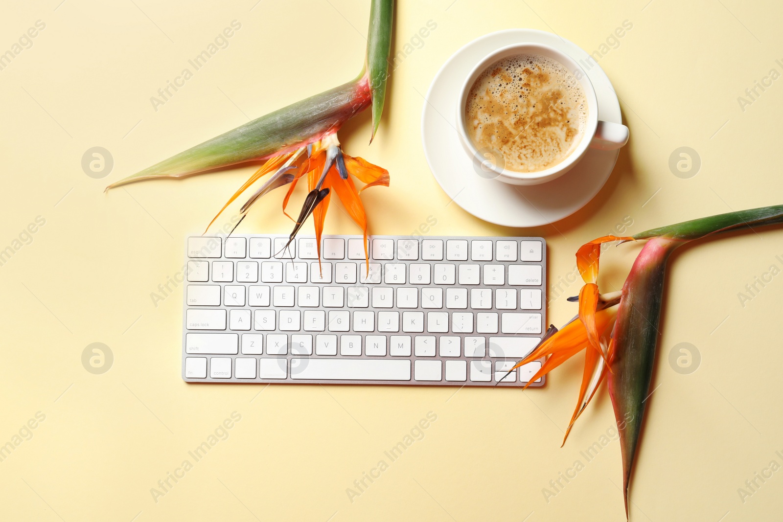 Photo of Creative flat lay composition with tropical flowers, cup of coffee and computer keyboard on color background