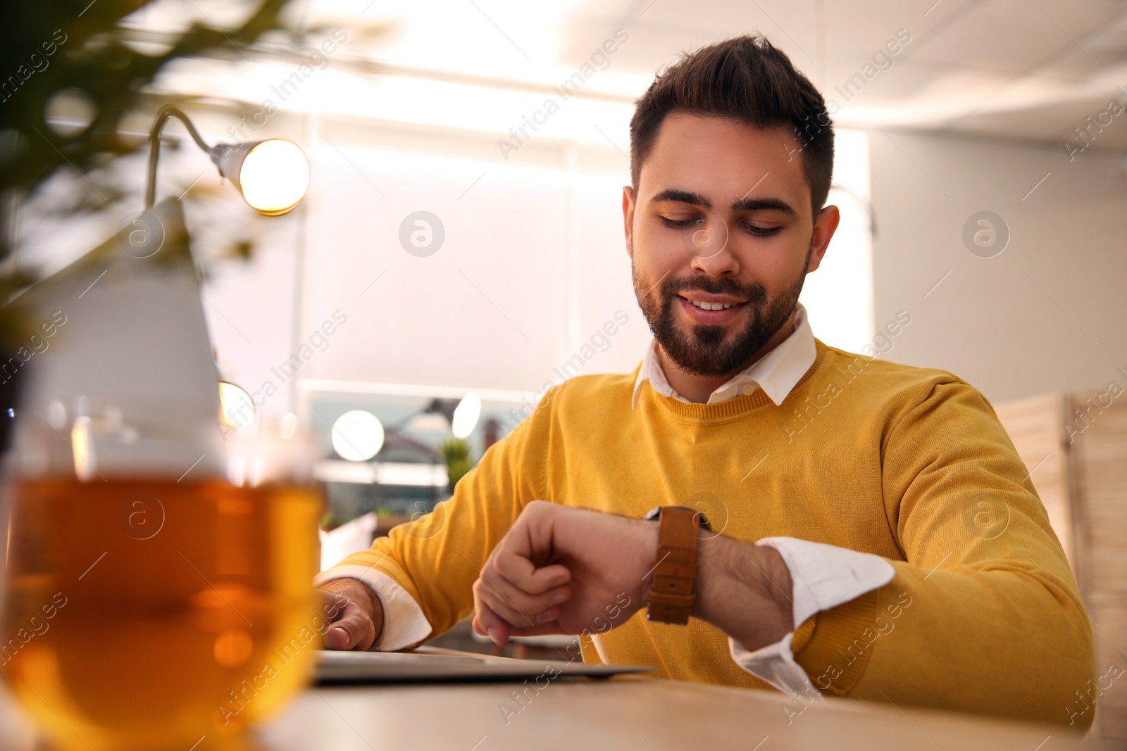 Photo of Man working with laptop at table in cafe