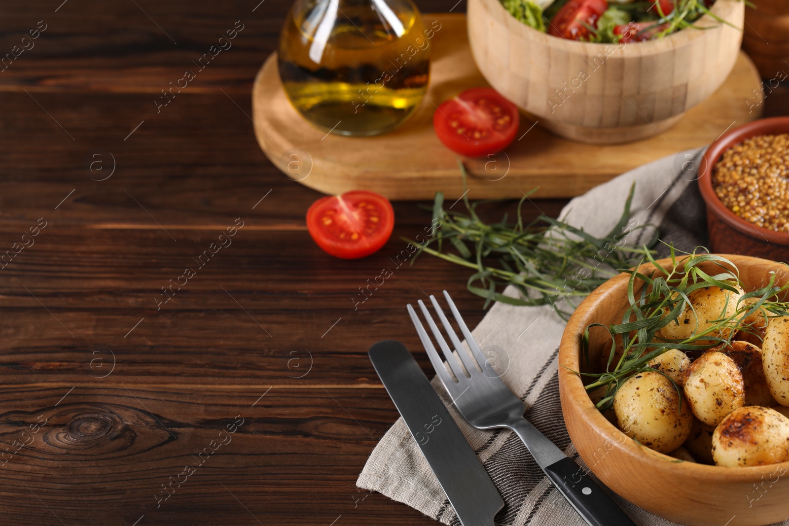 Photo of Delicious grilled potatoes with tarragon, mustard and salad on wooden table. Space for text