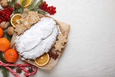 Traditional Christmas Stollen with icing sugar on white wooden table, flat lay. Space for text