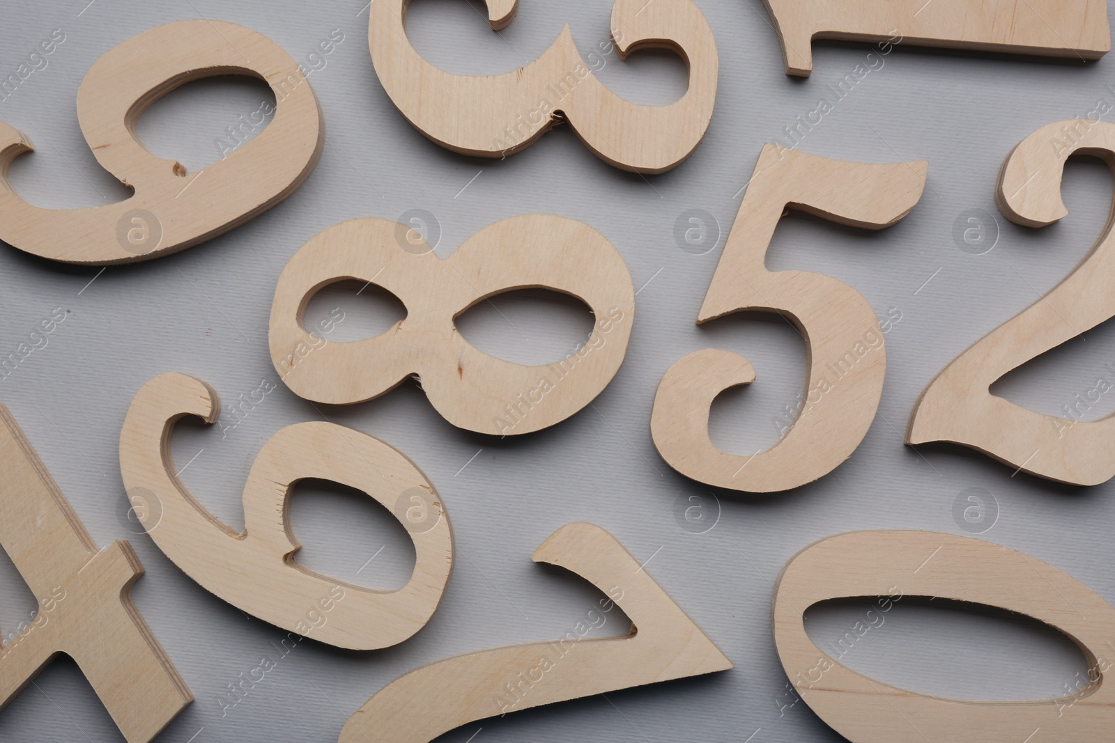 Photo of Wooden numbers on light grey background, flat lay