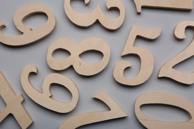 Wooden numbers on light grey background, flat lay