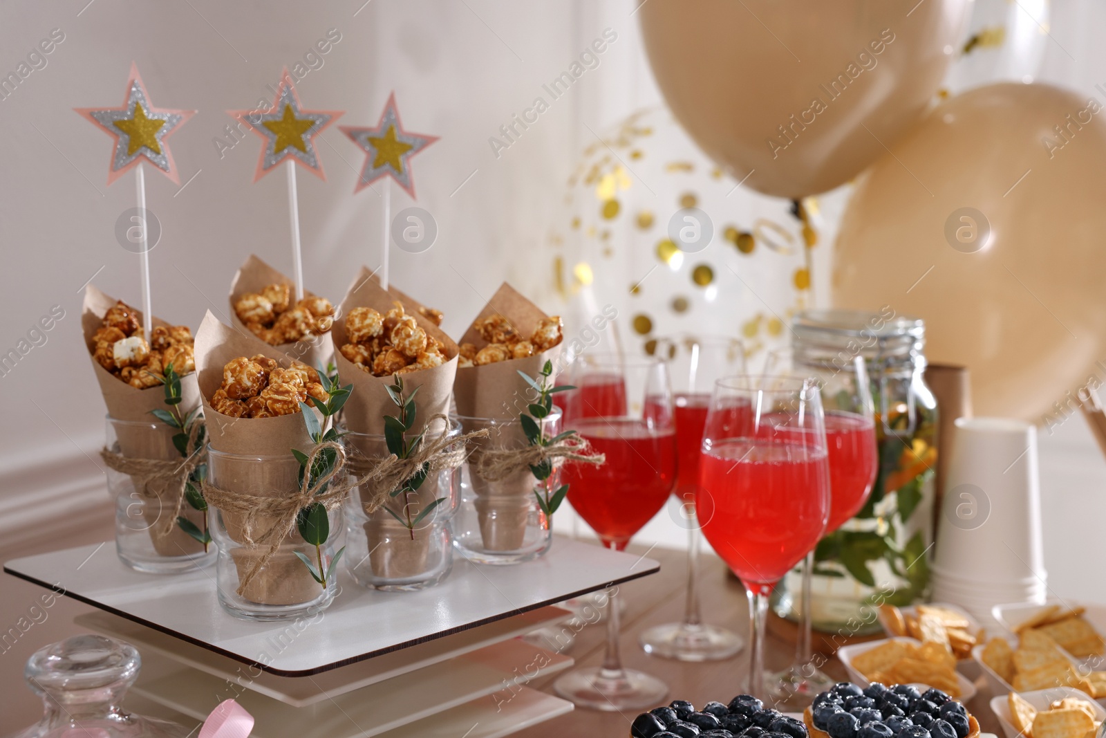 Photo of Delicious party treats and drinks on wooden table indoors