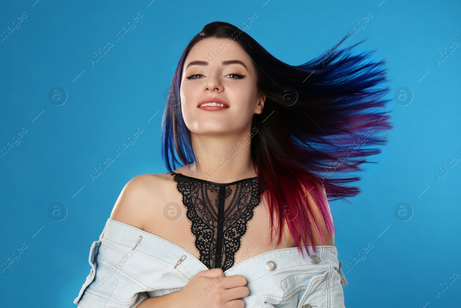 Photo of Young woman with bright dyed hair on blue background