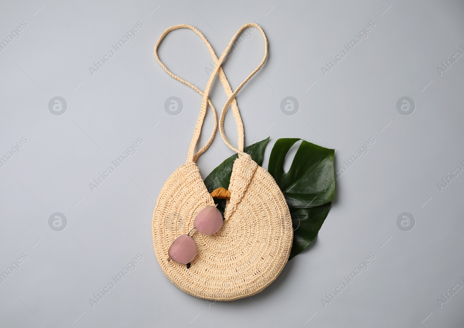 Photo of Stylish straw bag and sunglasses on grey background, flat lay. Summer accessories