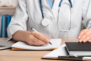 Doctor working at desk in office, closeup. Medical service