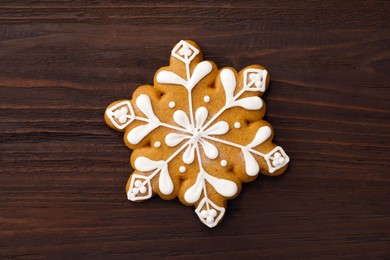 Photo of Snowflake shaped Christmas cookie on wooden table, top view