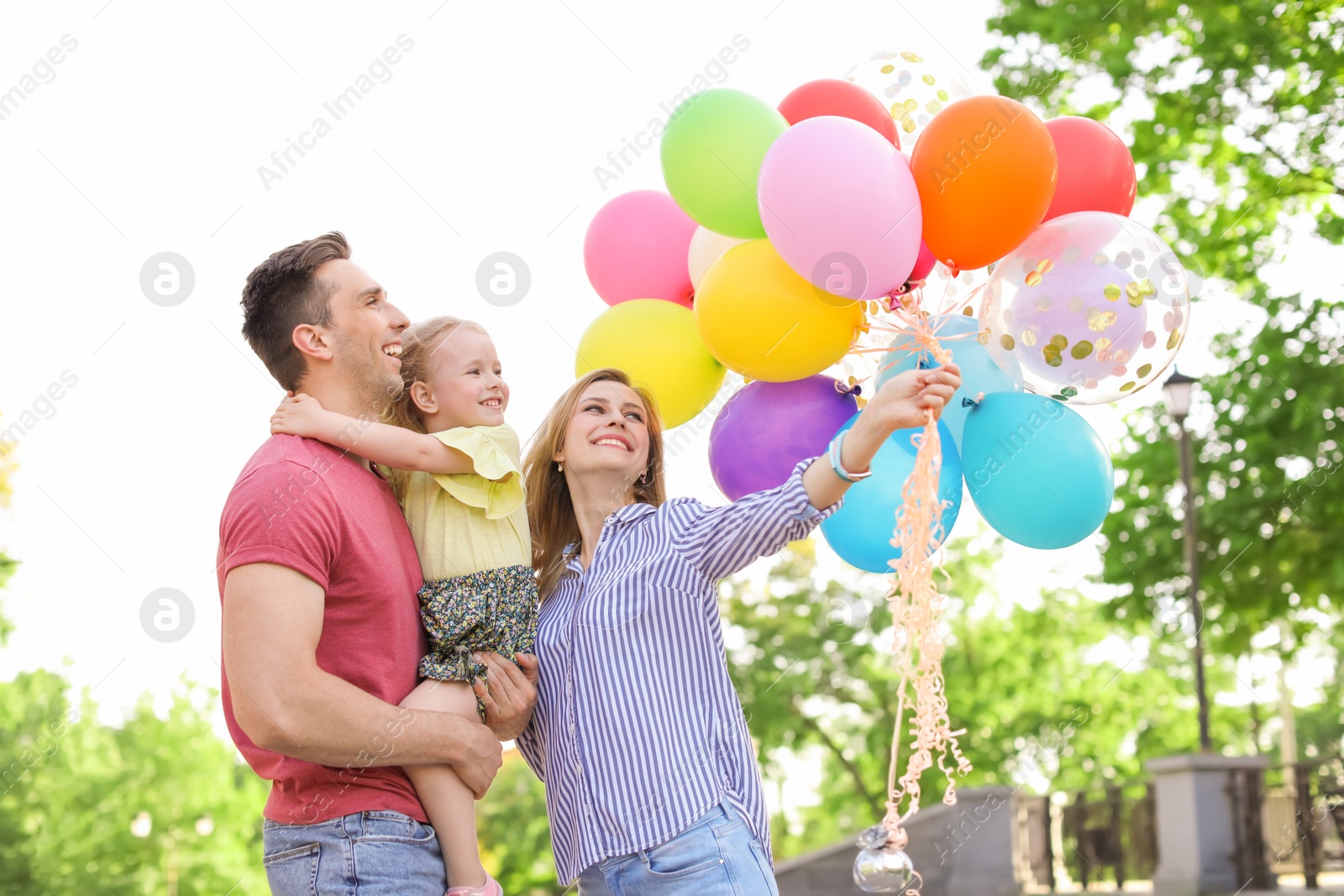 Photo of Happy family with colorful balloons outdoors on sunny day