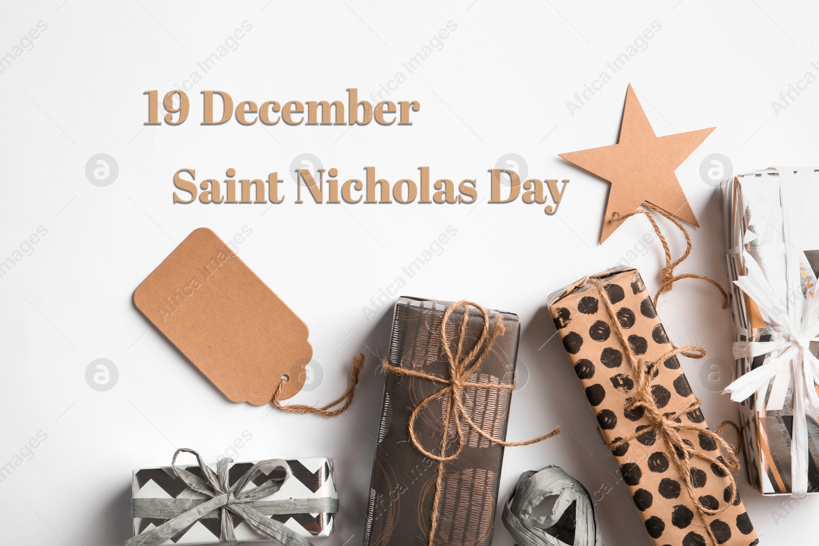 Image of 19 December Saint Nicholas Day. Beautiful gift boxes with tags on white background, top view