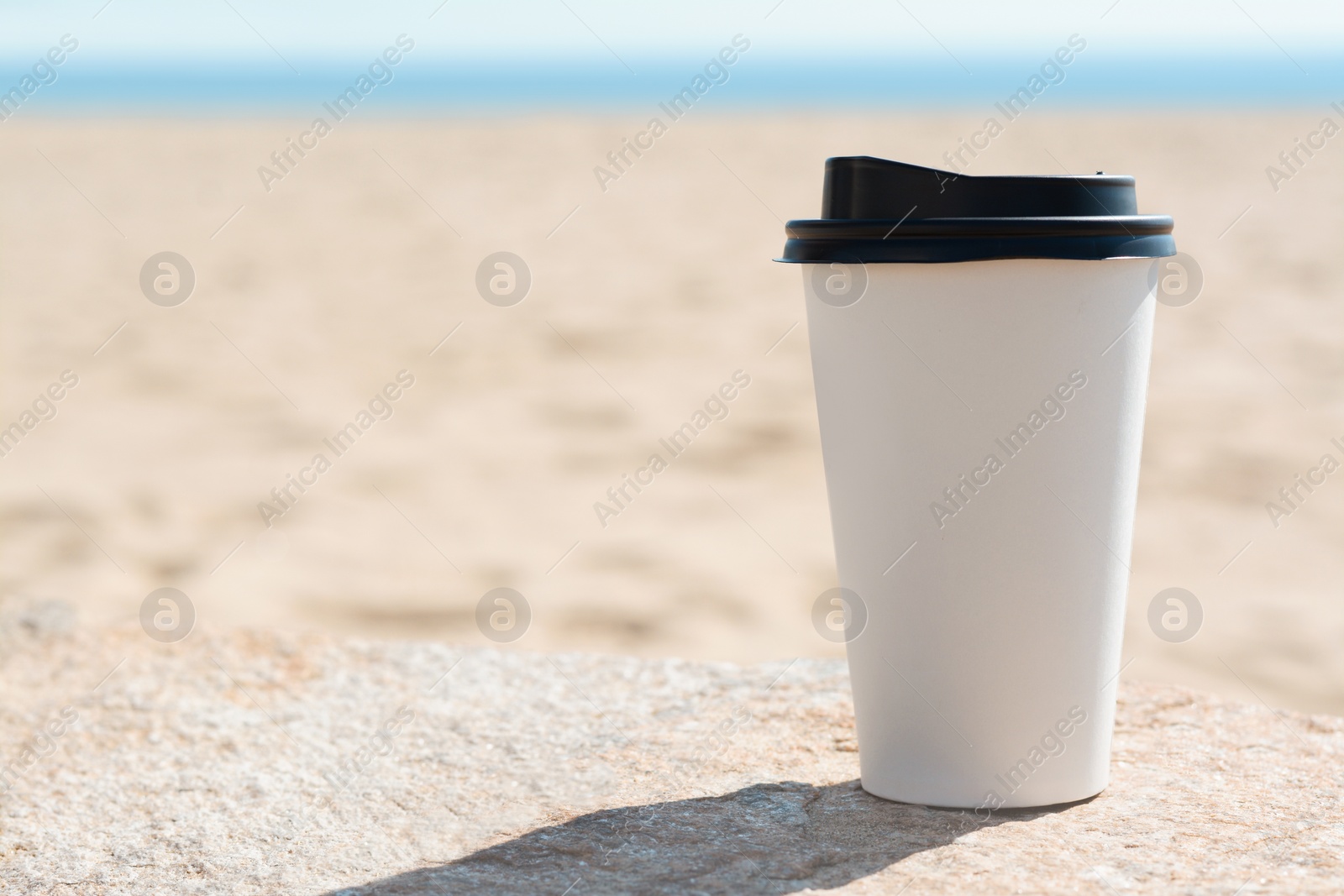 Photo of Takeaway coffee cup on beach, space for text