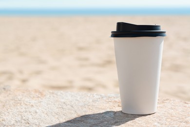 Photo of Takeaway coffee cup on beach, space for text