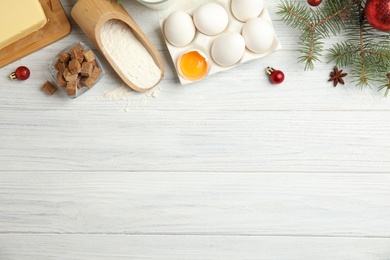 Photo of Flat lay composition with ingredients for traditional Christmas cake on white wooden table. Space for text