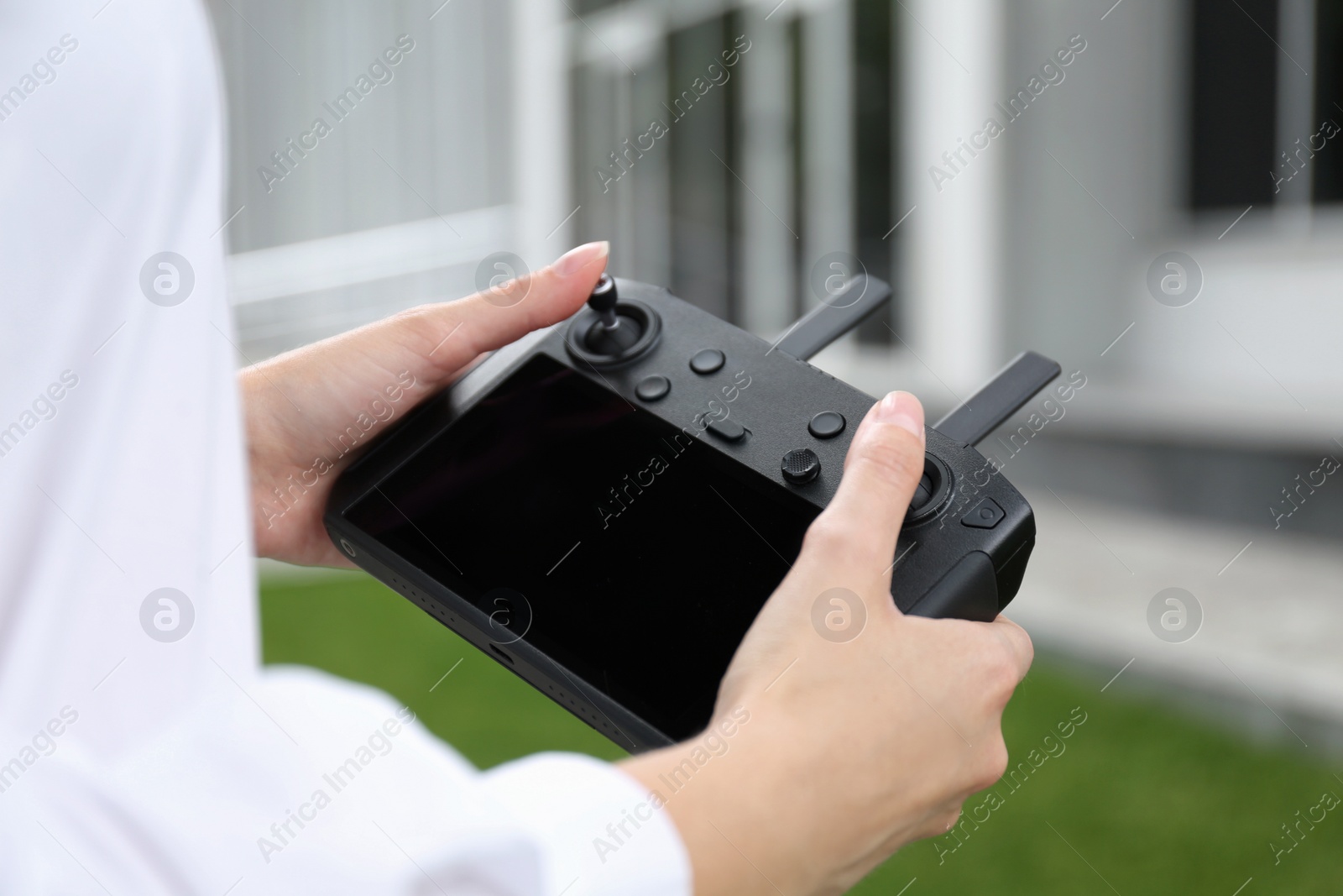 Photo of Woman with modern drone controller outdoors, closeup