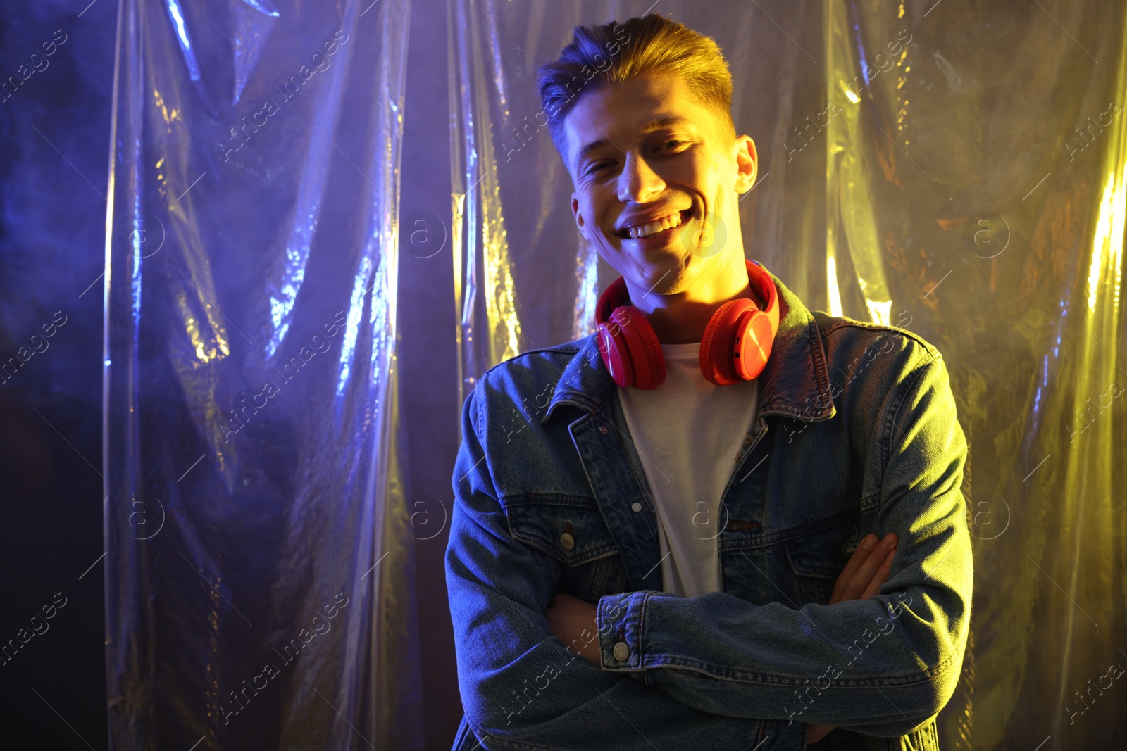 Photo of Young man with headphones in neon lights