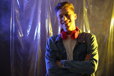 Young man with headphones in neon lights