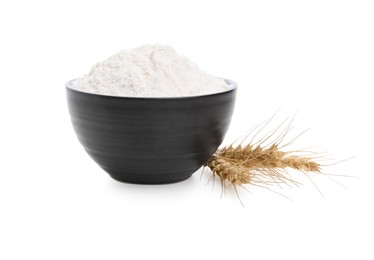 Photo of Bowl with wheat flour and spikes on white background