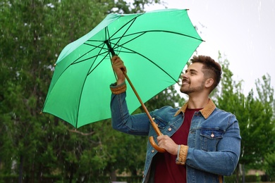 Photo of Man with umbrella outdoors on rainy day