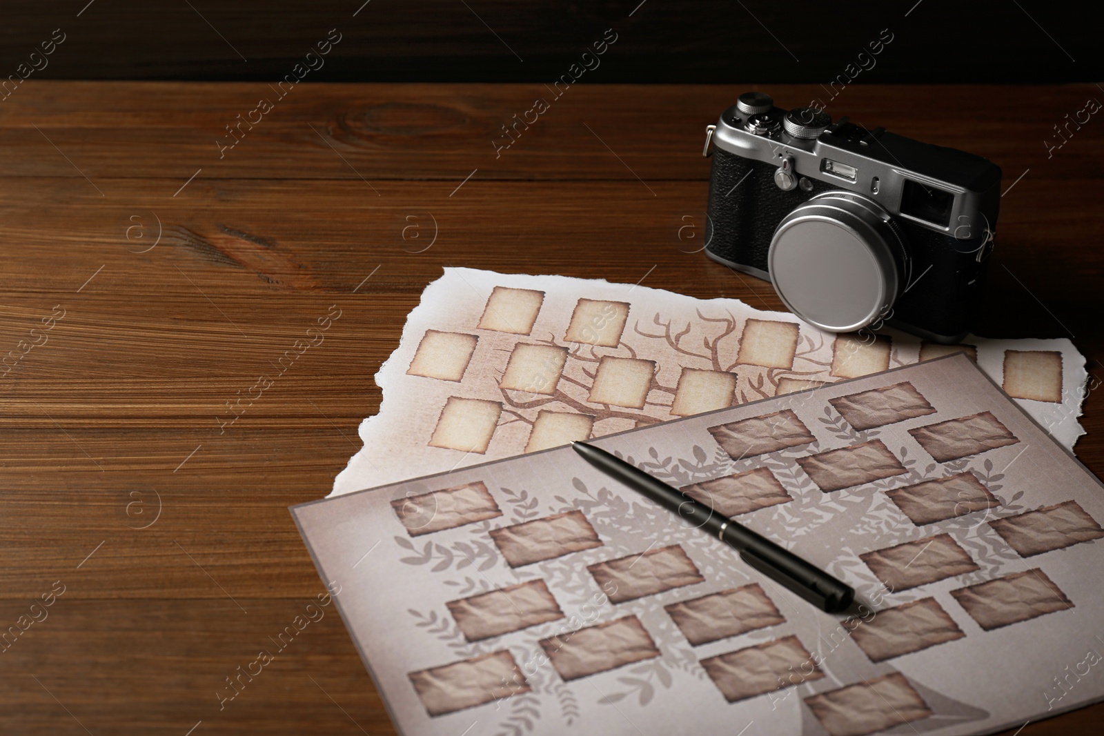 Photo of Papers with family tree templates, vintage camera and pen on wooden table. Space for text