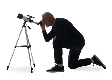 Senior astronomer looking at stars through telescope on white background