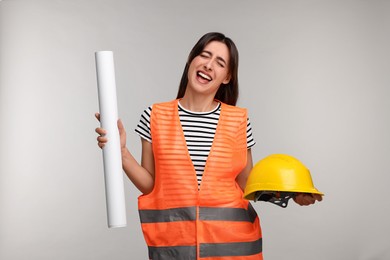 Photo of Architect with hard hat and draft on light grey background