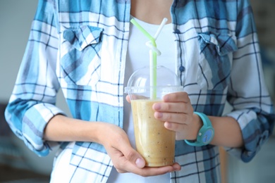 Photo of Young woman with plastic cup of healthy smoothie, closeup