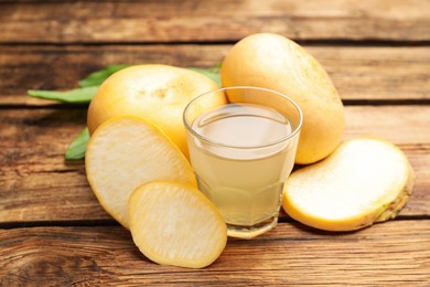 Photo of Glass of freshly made turnip juice on wooden table