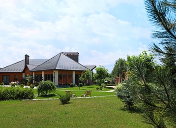 Modern house and beautiful garden on sunny day