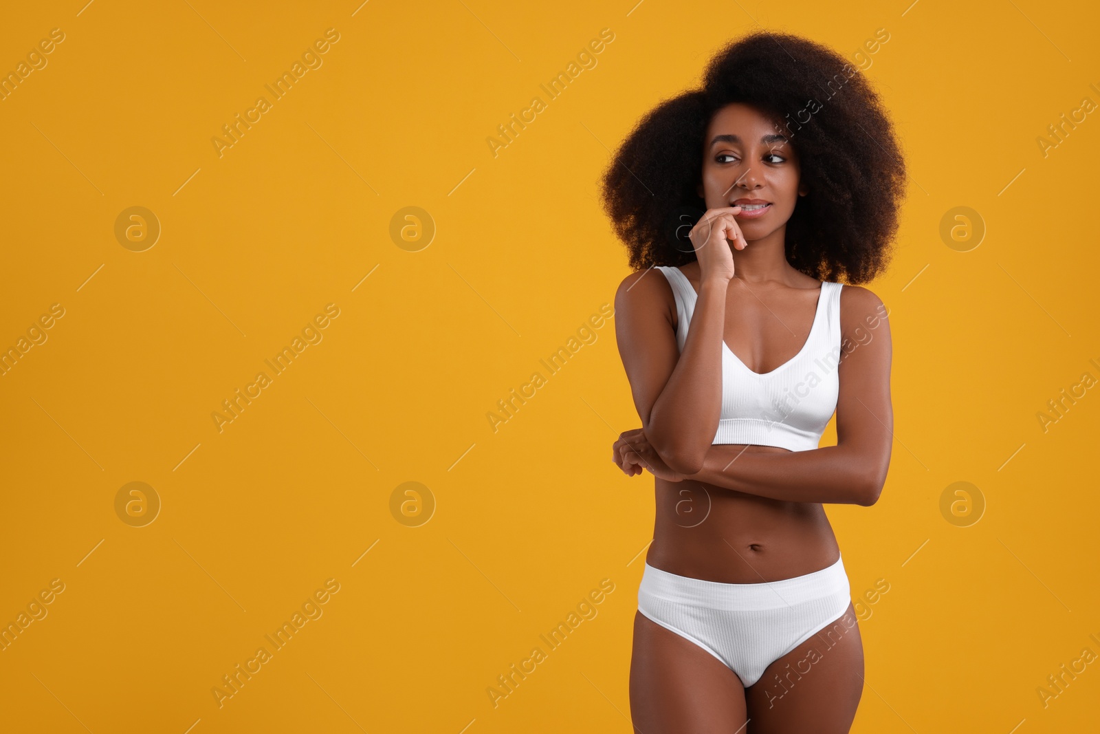 Photo of Beautiful woman in stylish bikini on yellow background, space for text