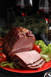 Plate with delicious ham, lettuce and tomatoes on black wooden table