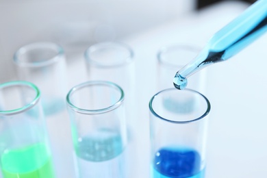 Photo of Dripping sample into test tube in chemistry laboratory, closeup