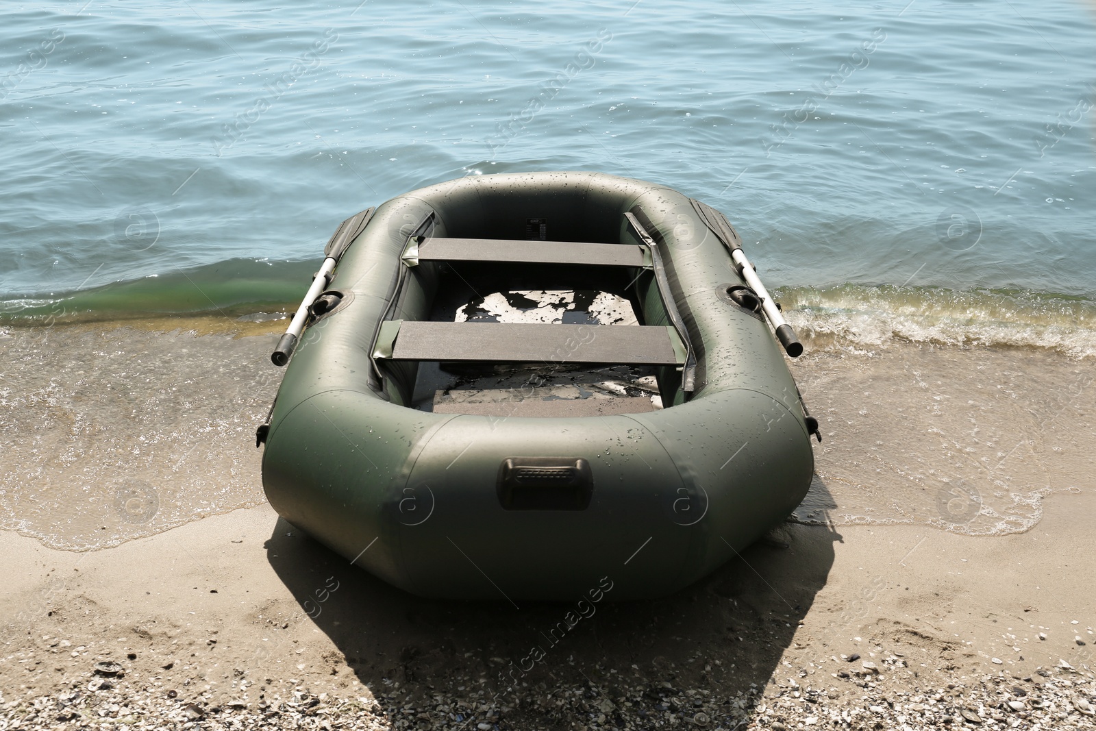 Photo of Inflatable rubber fishing boat on sandy beach near sea