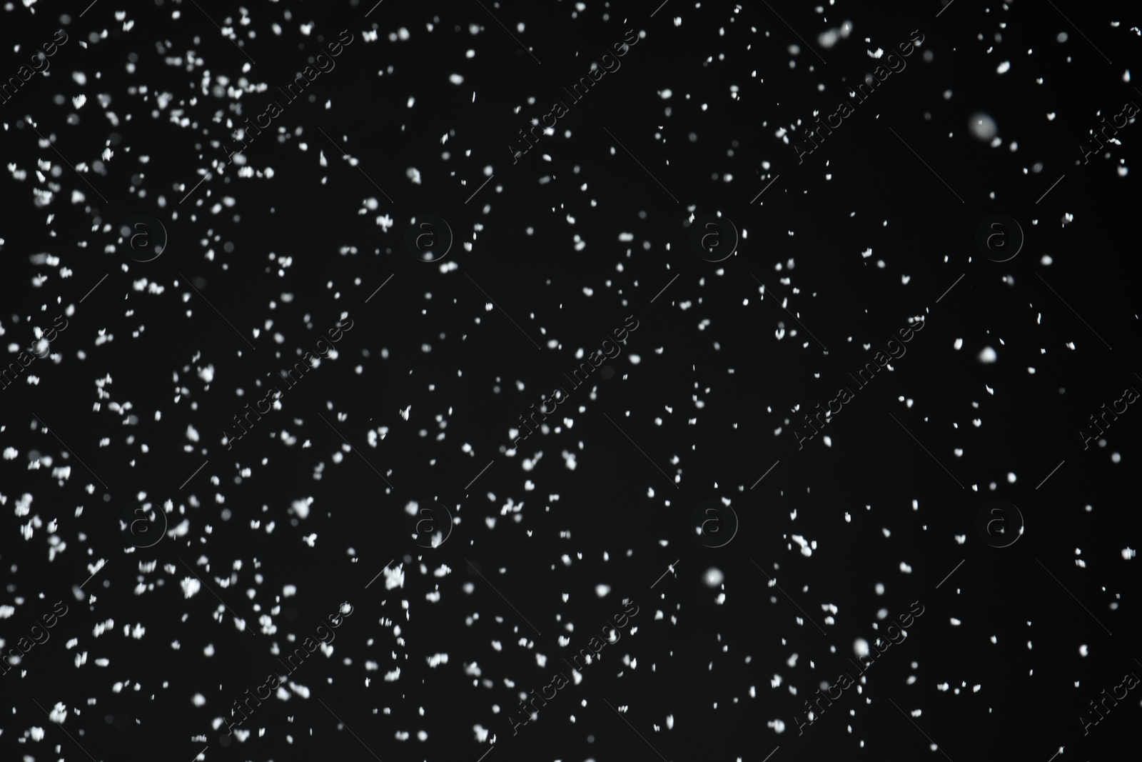 Photo of White snow falling down on black background