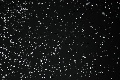 White snow falling down on black background