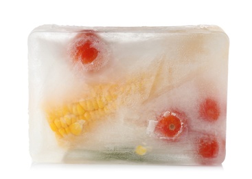 Photo of Fresh vegetables frozen in ice cube on white background