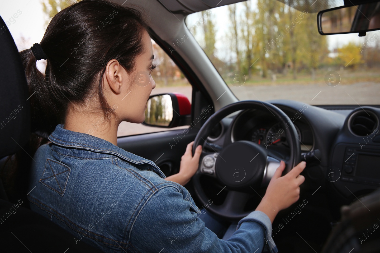 Photo of Young woman driving car on city road