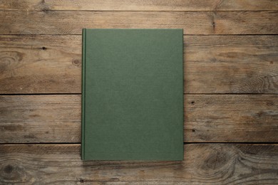 Photo of Closed hardcover book on wooden table, top view