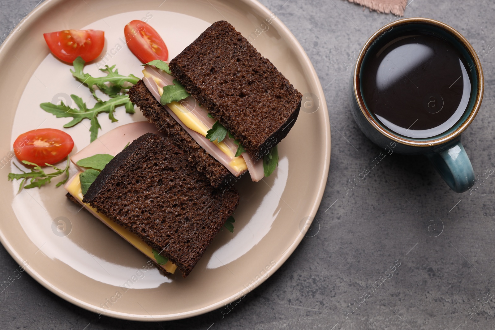 Photo of Delicious sandwiches with boiled sausage, tomato, cheese and arugula on grey table, flat lay