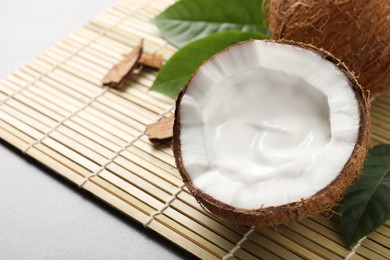 Ripe coconut with cream on bamboo mat. Space for text