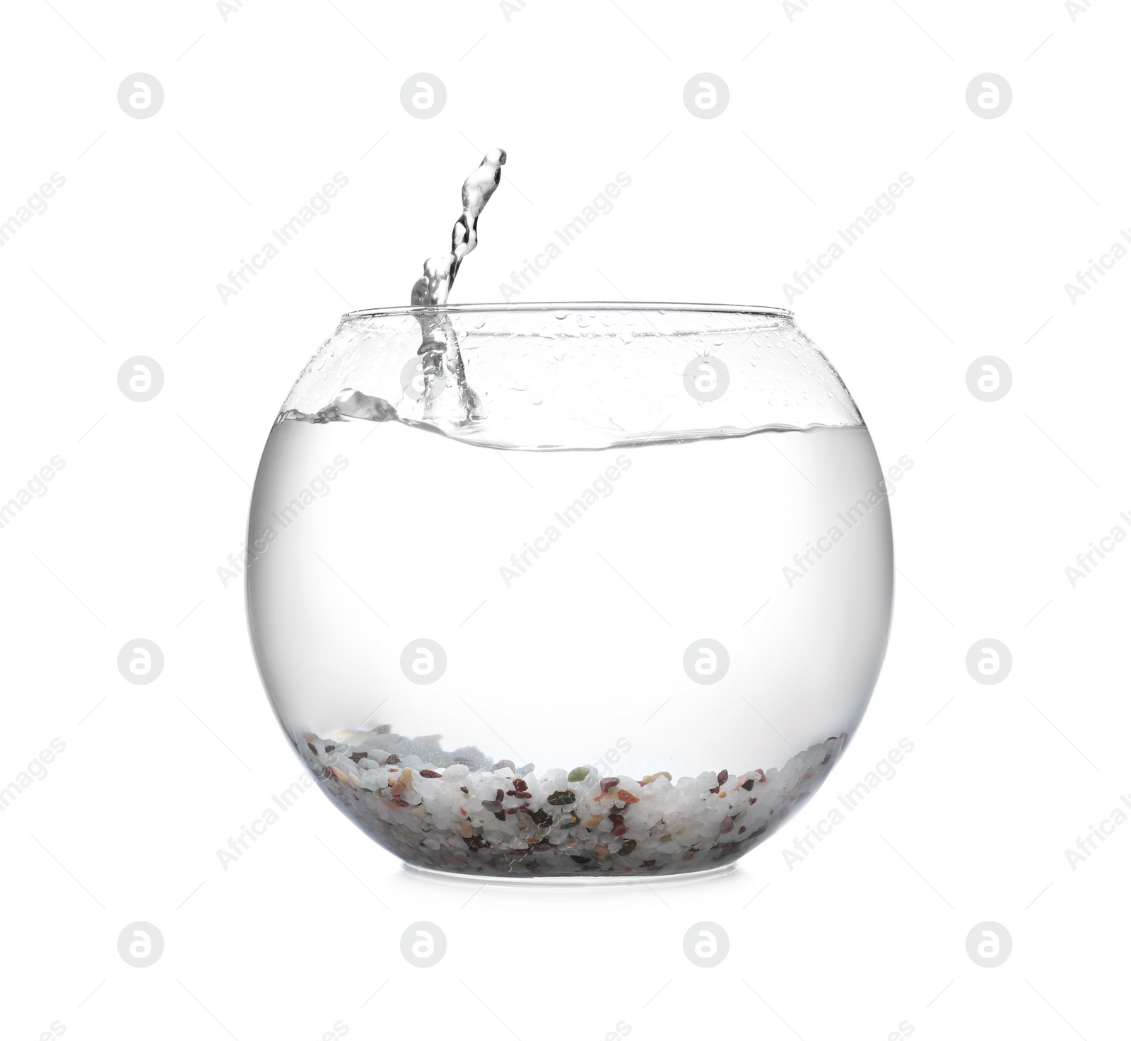 Photo of Splash of water in round fish bowl with decorative pebbles on white background