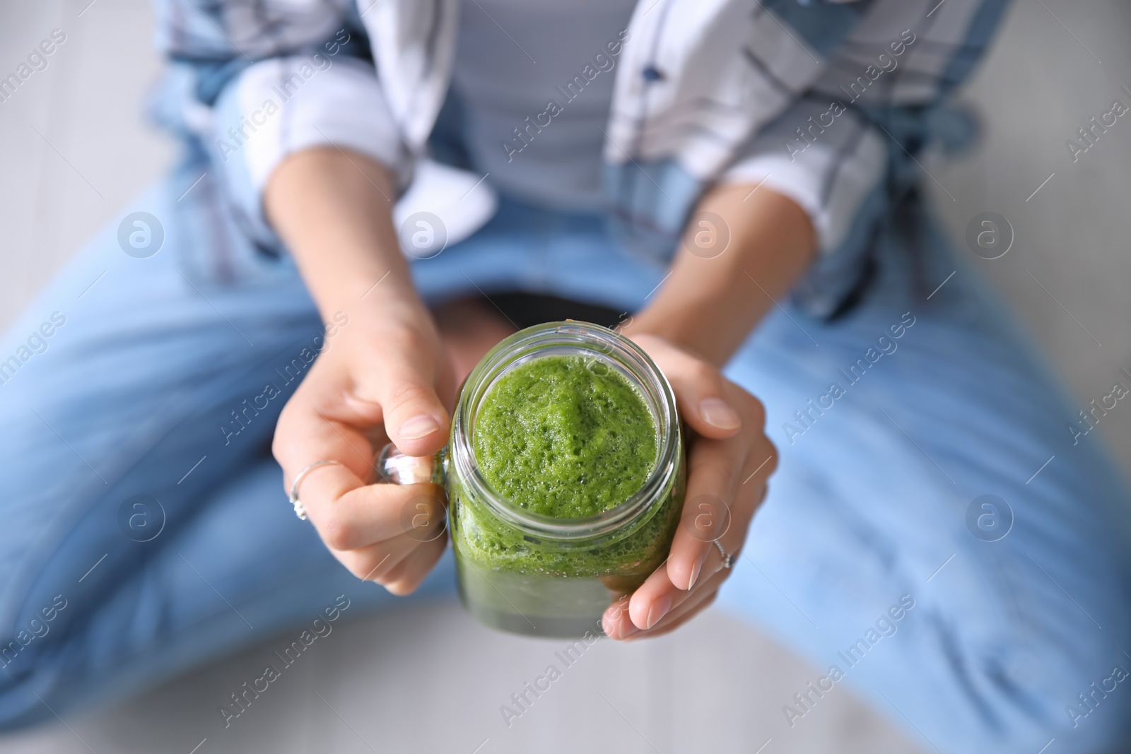 Photo of Young woman with mason jar of healthy smoothie, closeup