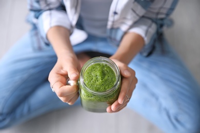 Photo of Young woman with mason jar of healthy smoothie, closeup