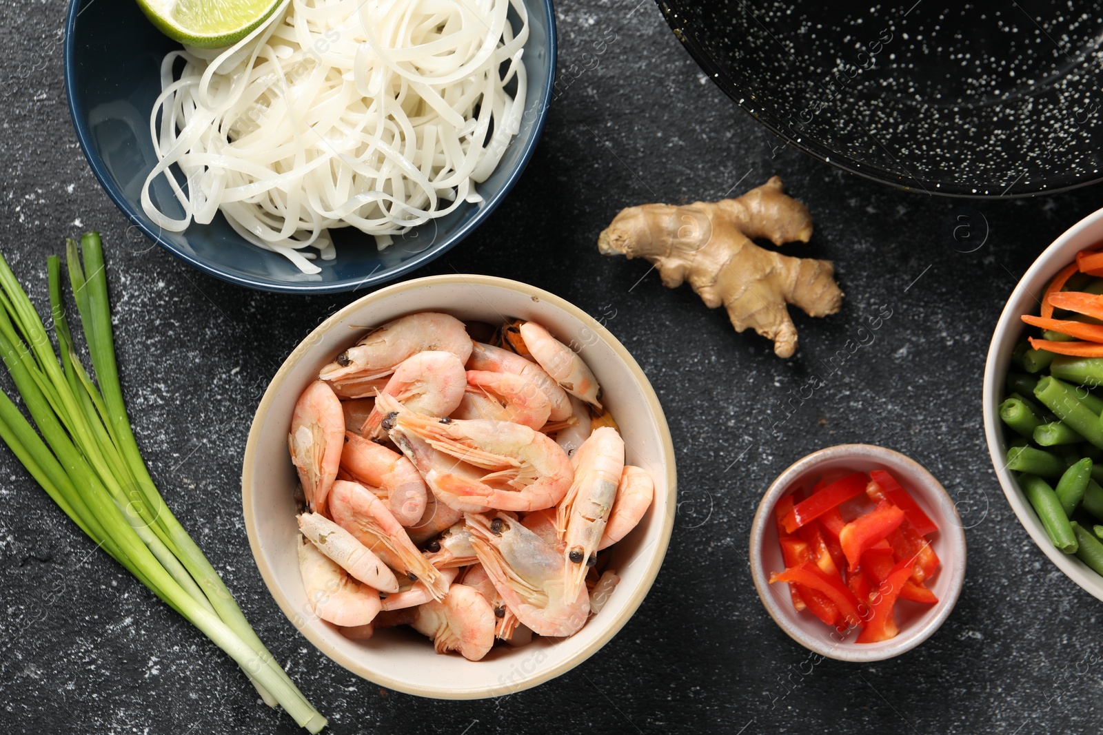 Photo of Flat lay composition with products for cooking wok on dark textured table