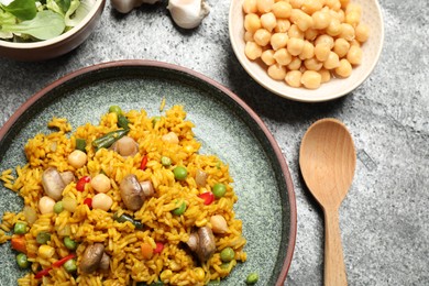 Delicious rice pilaf with vegetables served on grey table, flat lay