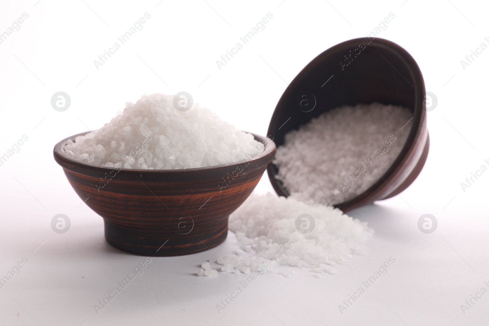 Photo of Natural salt in bowls on white background