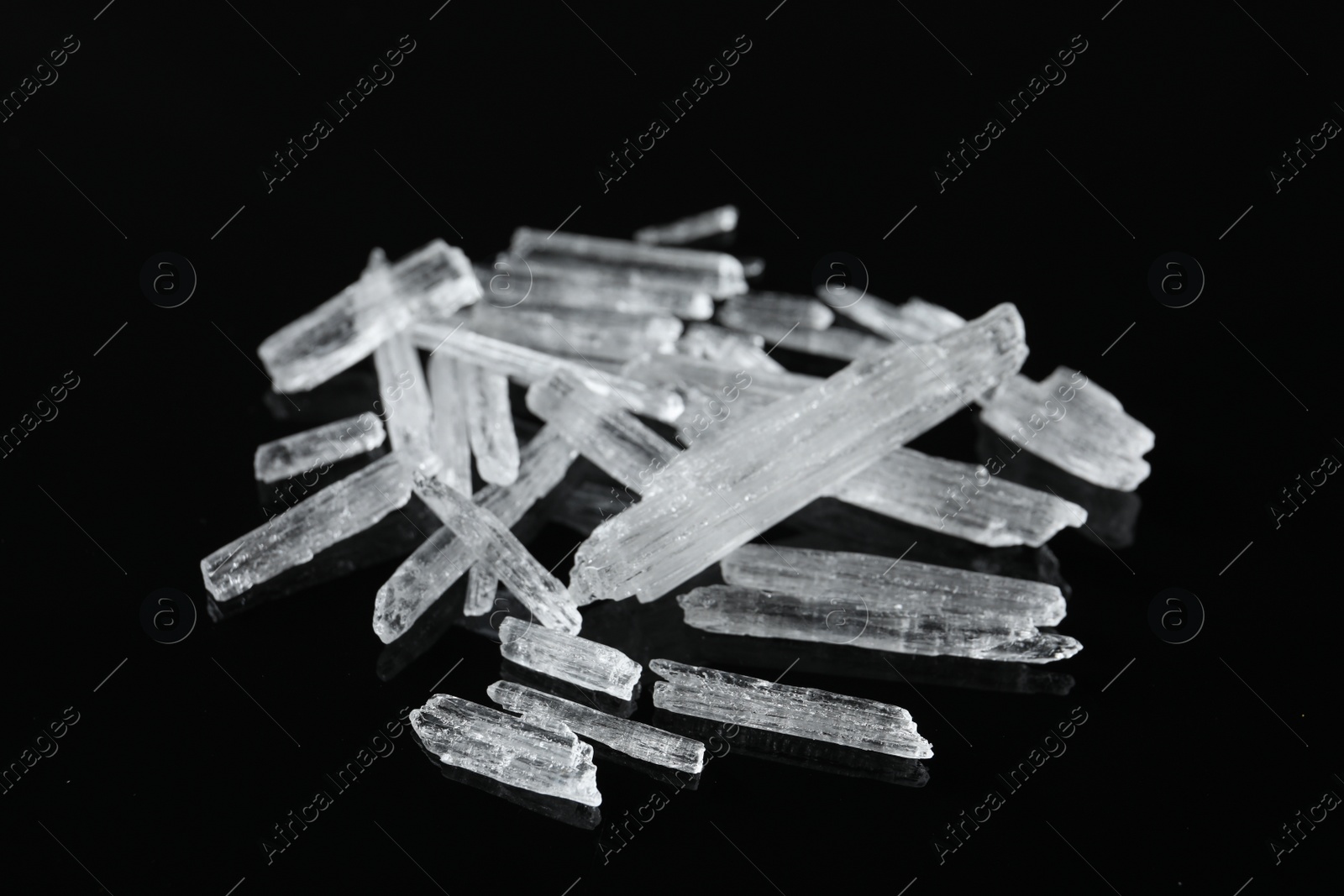 Photo of Menthol crystals on black background, closeup view