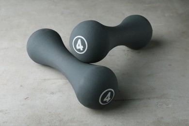 Photo of Grey rubber coated dumbbells on light table