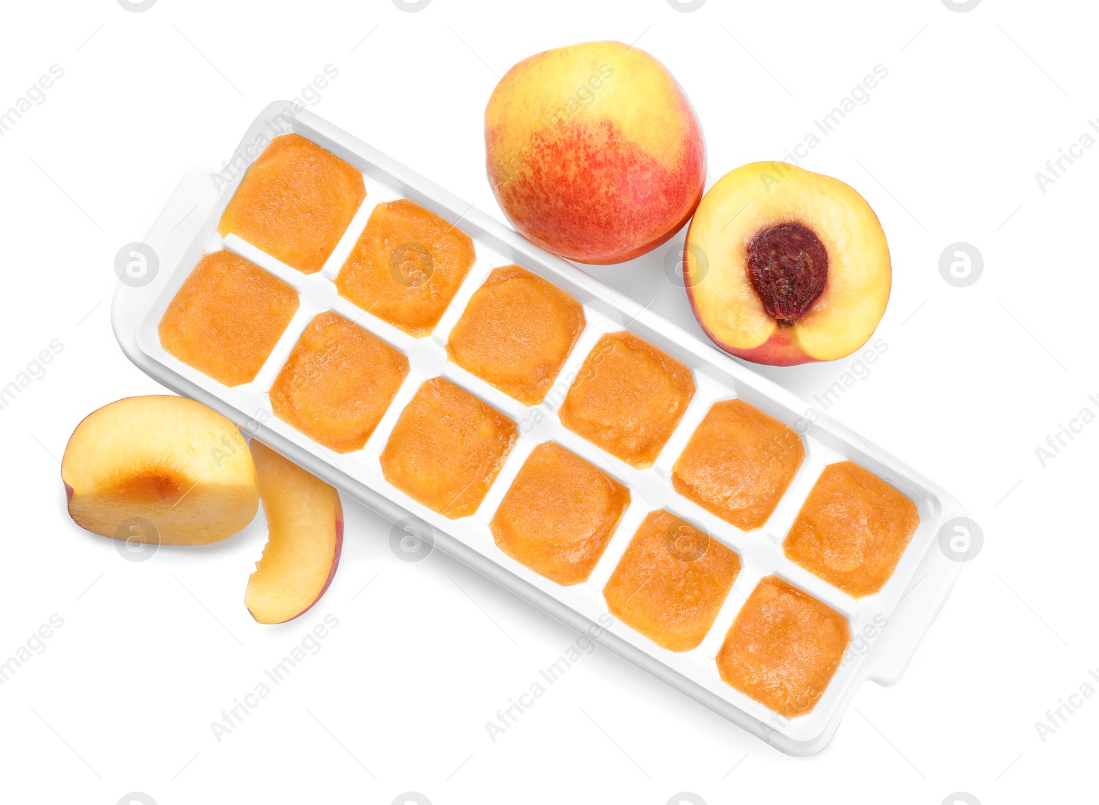 Photo of Nectarine puree in ice cube tray and ingredients on white background, top view. Ready for freezing