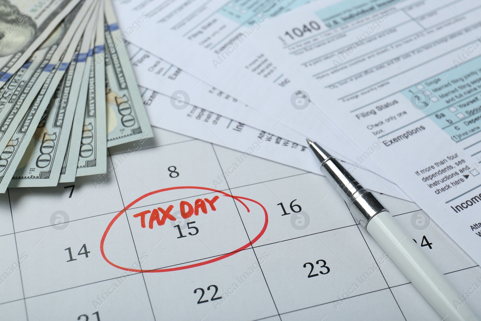 Photo of Calendar with date reminder about tax day, documents, pen and money, closeup